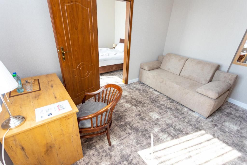Living area of a suite with a sofa and desk